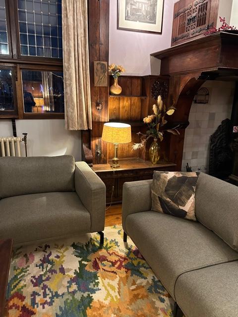 Cozy living space on Houseboat De Zwerver at Marina Parcs Naarden, Netherlands, with modern gray sofas.