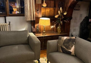 Cozy living space on Houseboat De Zwerver at Marina Parcs Naarden, Netherlands, with modern gray sofas.