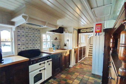 Acogedora cocina de la casa flotante De Zwerver en Marina Parcs Naarden, Países Bajos, con decoración clásica.