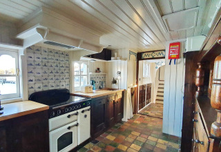 Acogedora cocina de la casa flotante De Zwerver en Marina Parcs Naarden, Países Bajos, con decoración clásica.