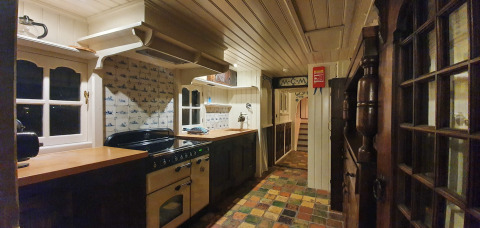 Cuisine traditionnelle du houseboat De Zwerver à Marina Parcs Naarden, Pays-Bas, avec sol en carrelage coloré.