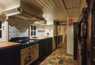 Küche auf dem Hausboot De Zwerver bei Marina Parcs Naarden, Niederlande, mit klassischen Fliesen und Holzdekor.