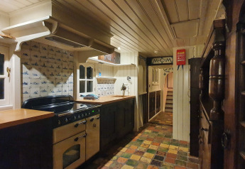 Rustikt køkken ombord på husbåden De Zwerver ved Marina Parcs Naarden i Holland, med farverige fliser.