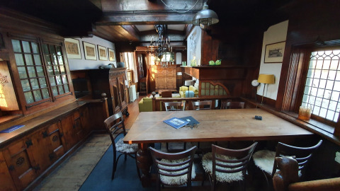 Gezellige eetkamer met houten meubilair op woonboot De Zwerver in Marina Parcs Naarden, Nederland.