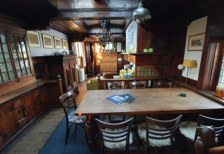 Gezellige eetkamer met houten meubilair op woonboot De Zwerver in Marina Parcs Naarden, Nederland.