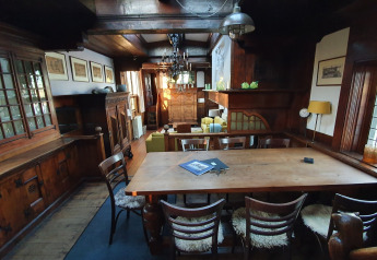 Salle à manger conviviale avec meubles en bois sur la péniche De Zwerver à Marina Parcs Naarden, Pays-Bas.