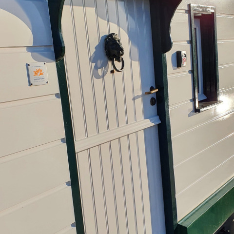 Ingang van woonboot De Zwerver bij Marina Parcs Naarden, Nederland, met deurklopper in leeuwenkop.