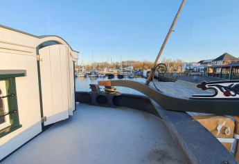 Vue depuis la Houseboat De Zwerver à Marina Parcs Naarden, montrant le port, les bateaux et des bâtiments.