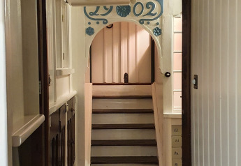 Hallway with stairs and decorative sign inside Houseboat De Zwerver at Marina Parcs Naarden, Netherlands.