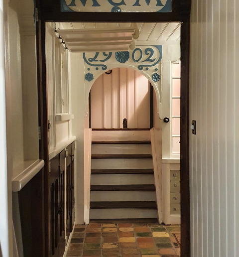Hallway with stairs and decorative sign inside Houseboat De Zwerver at Marina Parcs Naarden, Netherlands.
