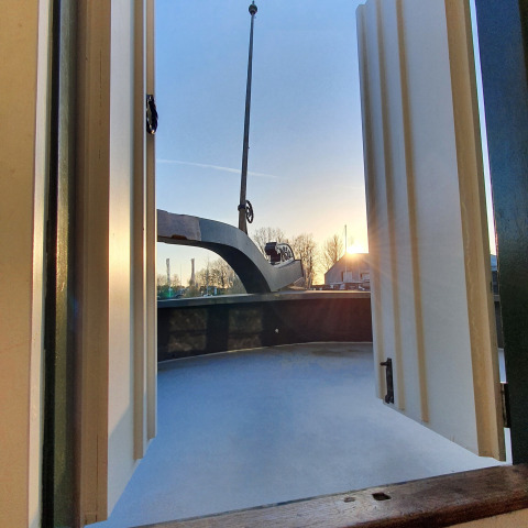 Vue à travers les portes d'une péniche au coucher du soleil à Marina Parcs Naarden, Pays-Bas.