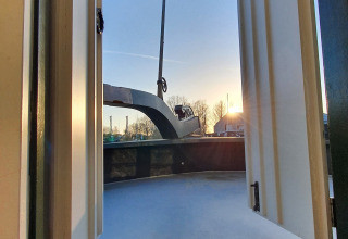 Vista dalle porte aperte di una houseboat al tramonto a Marina Parcs Naarden, Paesi Bassi.