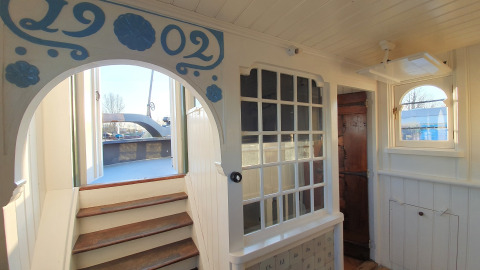 Interieur van woonboot De Zwerver bij Marina Parcs Naarden, Nederland, met trap naar het dek.