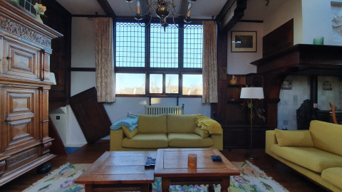 Sala de estar en la casa flotante De Zwerver en Marina Parcs Naarden, Países Bajos, con sofás amarillos.