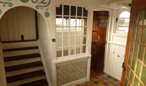 Bright and charming interior of Houseboat De Zwerver at Marina Parcs Naarden, Netherlands, wooden staircase visible.