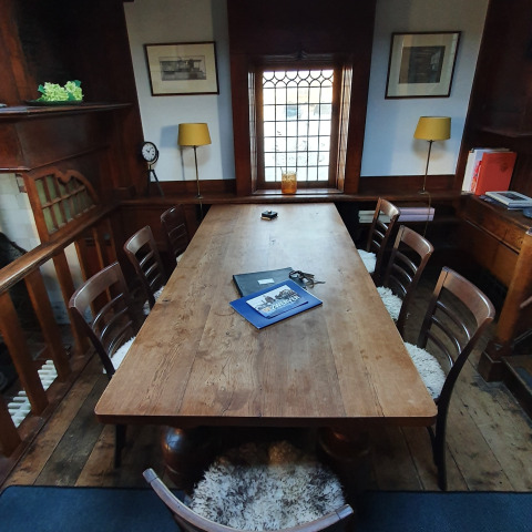 Een houten tafel met stoelen in een knusse ruimte op houseboat De Zwerver in Marina Parcs Naarden, Nederland.