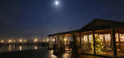 Sfeervolle avondfoto van Houseboat De Zwerver bij Marina Parcs Naarden, Nederland, onder een heldere maan.