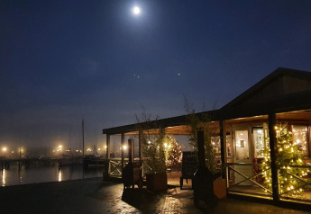 Avondfoto van Houseboat De Zwerver bij Marina Parcs Naarden in Nederland, verlicht door de volle maan.