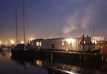 Avondfoto van Houseboat De Zwerver aan Marina Parcs Naarden in Nederland, sfeervol verlicht en rustig.