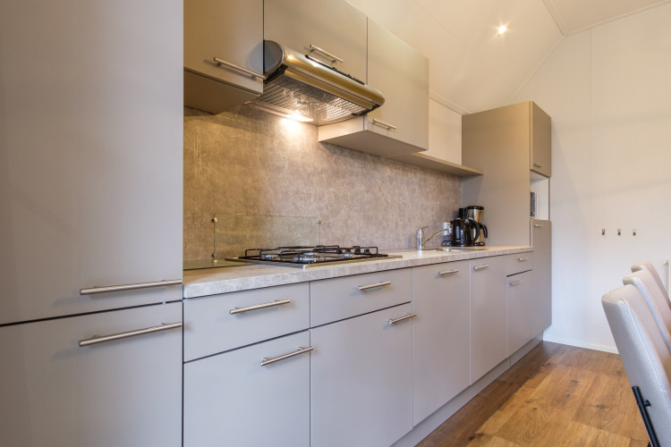 Moderne keuken in de Vechtdallodge bij Kampeerdorp de Zandstuve, Nederland, met fornuis en kasten.