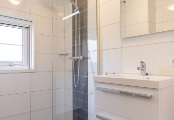 Moderne badeværelse med glasbruseniche og håndvask, Vechtdallodge i Kampeerdorp de Zandstuve, Holland.