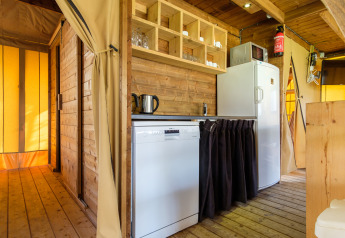 Interno della tenda safari Verandalodge al Kampeerdorp de Zandstuve nei Paesi Bassi, con cucina moderna.