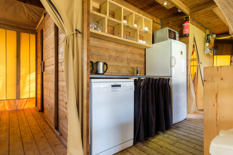 Binnenkant van de Verandalodge safaritent in Kampeerdorp de Zandstuve, Nederland, met keukenhoek.