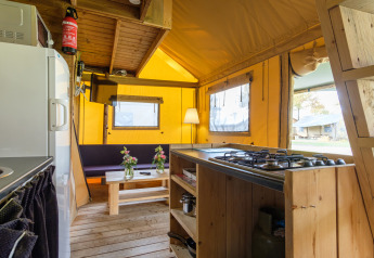 Interno della tenda safari Verandalodge a Kampeerdorp de Zandstuve, con cucina e zona soggiorno.