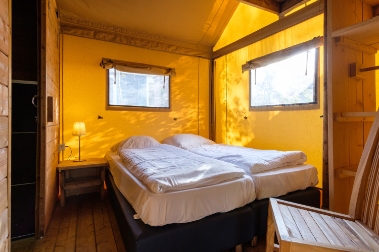 Slaapkamer in Verandalodge safaritent op Kampeerdorp de Zandstuve, Nederland, met twee bedden.