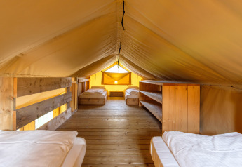 Interno della tenda safari Verandalodge con quattro letti a Kampeerdorp de Zandstuve, Paesi Bassi.