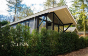 Moderne Bos Cottage lodge ved De Thijmse Berg i Holland, omgivet af natur og grønne træer.