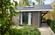Udsigt til Bos Cottage ved De Thijmse Berg i Nederlandene, omgivet af grønne planter og træer.