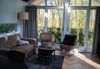 Stue i Bos Cottage på De Thijmse Berg, Holland, med store vinduer, naturudsigt og moderne møbler.