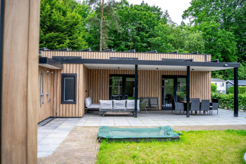 Zona exterior de la Wellness Cottage 6p en De Thijmse Berg, Países Bajos, con terraza y mobiliario moderno.