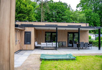 Zona exterior de la Wellness Cottage 6p en De Thijmse Berg, Países Bajos, con terraza y mobiliario moderno.