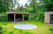 Giardino per famiglie con tappeto elastico, altalene e area picnic coperta al Wellness Cottage 6p a De Thijmse Berg.