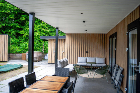 Terraza cubierta de Wellness Cottage 6p en De Thijmse Berg, Países Bajos, con modernos muebles exteriores.
