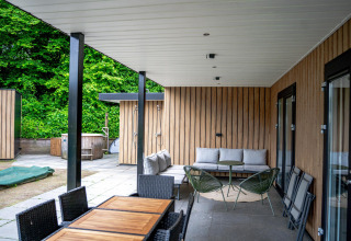 Udendørs terrasse ved Wellness Cottage 6p, De Thijmse Berg, Holland, med moderne møbler og grøn udsigt.