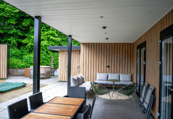 Udendørs terrasse ved Wellness Cottage 6p, De Thijmse Berg, Holland, med moderne møbler og grøn udsigt.