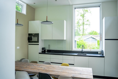Cocina moderna en Wellness Cottage 6p en De Thijmse Berg, Países Bajos, con gran ventana y mesa de comedor.