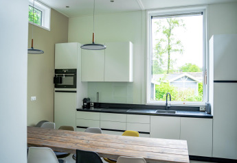 Moderne køkken i Wellness Cottage 6p på De Thijmse Berg, Holland, med stort vindue og spisebord.
