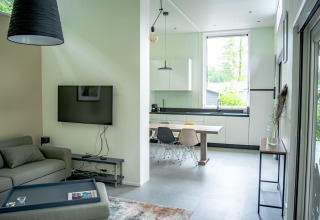 Moderne stue og køkken i Wellness Cottage 6p ved De Thijmse Berg, Holland. Store vinduer og stilfuldt interiør.