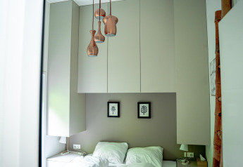 Camera da letto moderna con armadi bianchi, lampade a sospensione e letto doppio presso Wellness Cottage 6p.