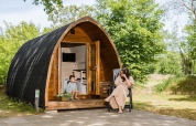 Une femme et un enfant se détendent devant un pod en bois à Kampeerdorp de Zandstuve, aux Pays-Bas.