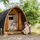 Una mujer y un niño disfrutan frente a una cabaña de madera en Kampeerdorp de Zandstuve, Países Bajos.