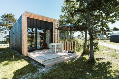 Moderne tiny house Klaproos met houten terras bij vakantiepark De Klepperstee in Nederland.