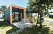 Casa pequeña Klaproos moderna con terraza de madera en el parque vacacional De Klepperstee, Países Bajos.