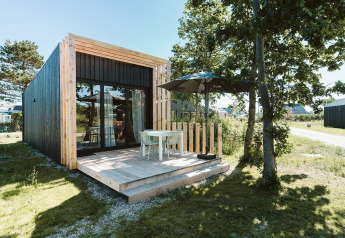 Moderne tiny house Klaproos met houten terras in vakantiepark De Klepperstee in Nederland.