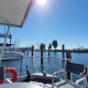 Vista desde la casa flotante Havenlodge Lelystad en Marina Parcs con yates y cielo soleado en los Países Bajos.