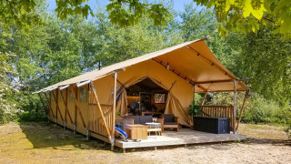 Gran tienda de safari lodge en Marina Parcs Almere, Países Bajos, rodeada de árboles y naturaleza verde.